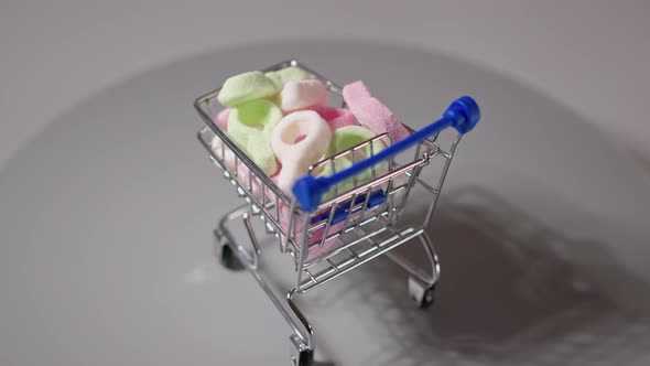 Close up view of colorful marmalade in trolley isolated. Unhealthy food concept.