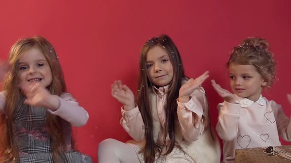 Lovely Cute Little Girls Sitting on the Studio Floor Among Beautifullt Wrapped Gifts alt