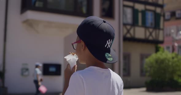 Little boy with tape on glasses eating ice cream in downtown Colmar, France