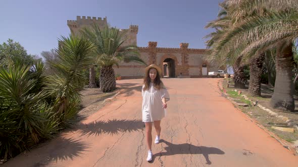 Beautiful woman walking near old luxury villa in Italy