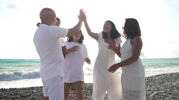 Happy Asian Man Giving Highfive in Sunrays to Daughters in Slow Motion Holding Baby Granddaughter on