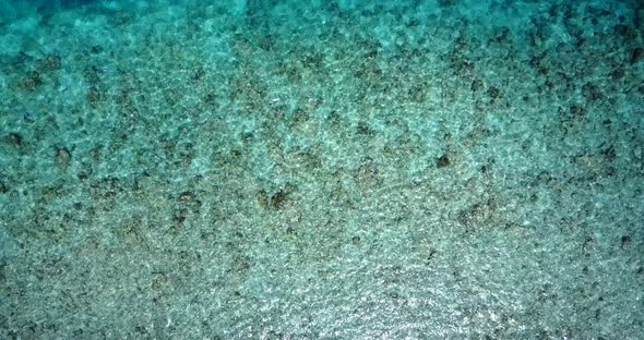 Beautiful flying abstract shot of a white sandy paradise beach and aqua blue ocean background in 4K