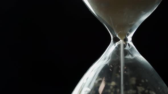 An Hourglass on a Black Background As a Concept of Passing Time for a Business Deadline