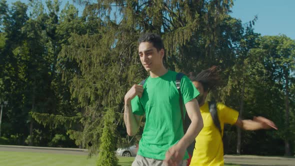 Joyful Man Piggybacking College Friends at Campus