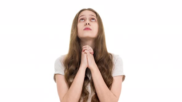 Portrait of Adolescent Woman with No Makeup Looking Up with Keeping Hands in Praying and Begging God