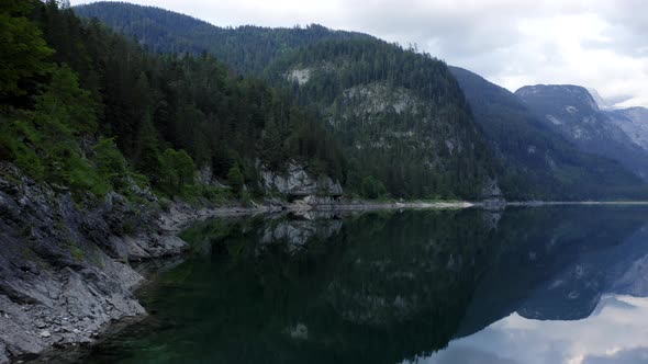 Aerial Fly Along Bank of Gosausee Lake in Low Altitude with Reflection in Upper Austria