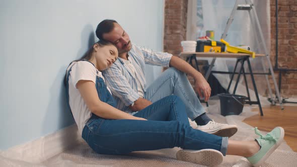 Young Happy Family Sitting on Floor Planning Design Project and Renovating House