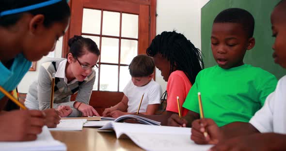 Teacher Helping Her Pupils During Class