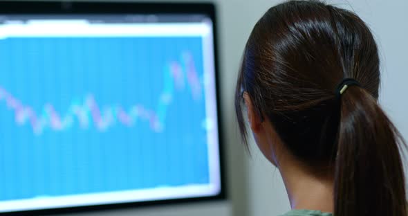 Woman work on stock photo market graph at night