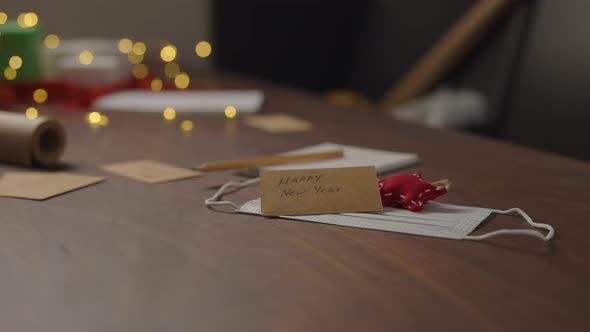 Orbit Shot of Medicine Mask Happy New Year Card and Decorations on Walnut Wood Table with Christmas