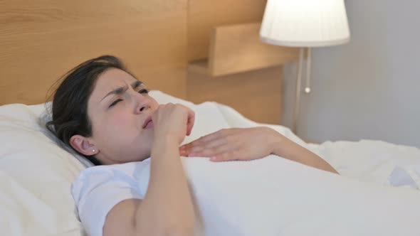 Young Indian Woman Coughing while Sleeping in Bed