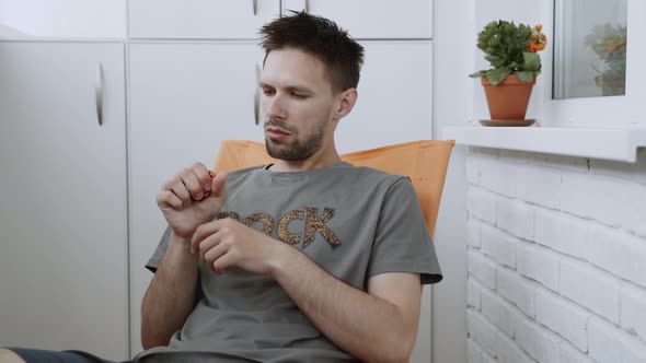 Serious and Tired Man Presses Anti Stress Ball for Relaxation