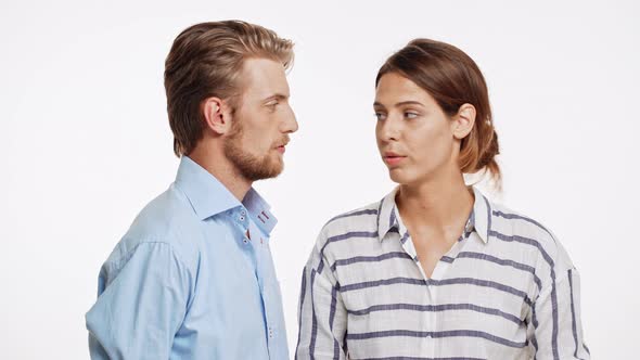 Beautiful Caucasian Couple Talking and Surprisingly Kissing on White Background