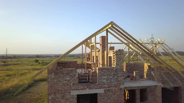 Aerial View of Unfinished Brick House with Wooden Roof Structure Under Construction