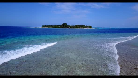 Aerial drone shot travel of marine coastline beach adventure by blue green lagoon and white sand bac