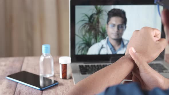 Sick Man Suffering Pain in Hand Consult Doctor Online Using Laptop