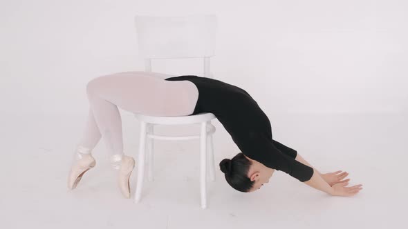 Ballerina in Black Performing with Chaior in White Studio Isolated
