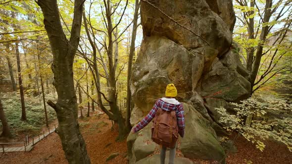 Travel in Ukraine Woman Hiker with Backpack Climbs Up a Huge Stone with Green Moss