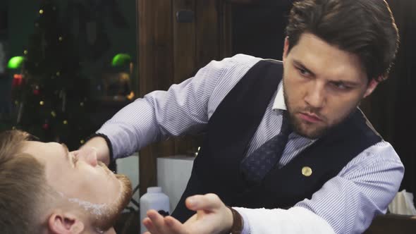 Professional Barber Shaving His Client with a Razor