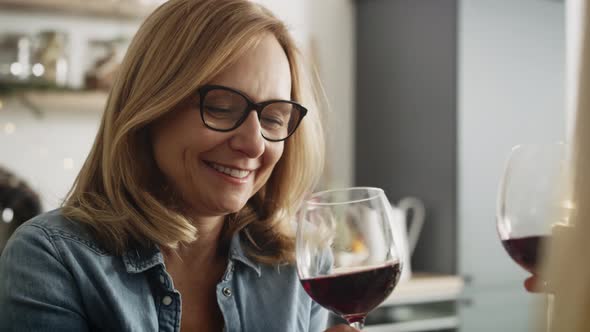 Handheld video of woman drinking wine at home. Shot with RED helium camera in 8K.