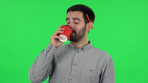 Portrait of Brunette Guy Is Enjoying Coffee. Green Screen