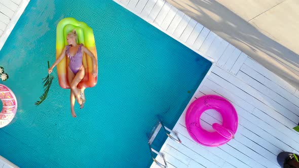 Top View Young Woman in Swimsuit Swims in Pool on Air Mattress