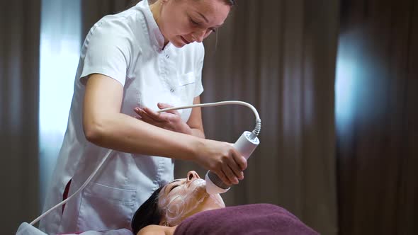 Cosmetologist Using Equipment for Rejuvenation Procedure