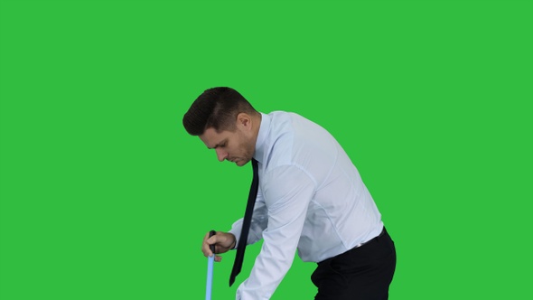 Man in official clother sweeping the floor on a Green Screen