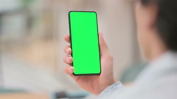 Rear View Man Using Smartphone with Green Chroma Key Screen