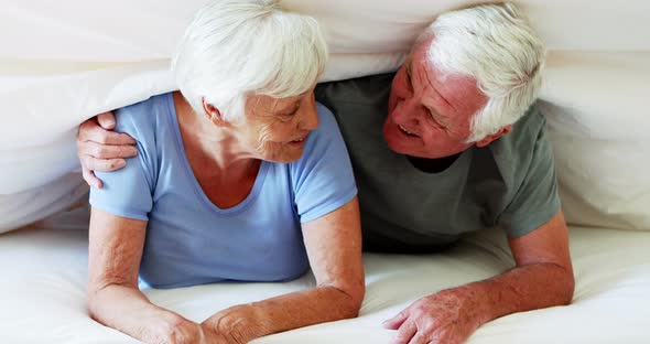 Happy senior couple lying on bed