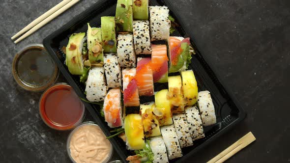 Asian Food Delivery Home, Various Sushi Sets in Plastic Containers with Sauces, Rice and Chopsticks