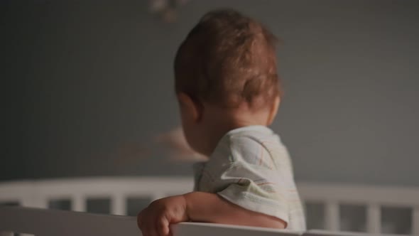 Young Mother and Baby in Crib at Night