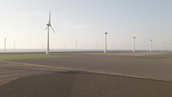 Revealing Wind farm landscape, Flock of Seagulls Following a tractor plowing the fields, Aerial pull