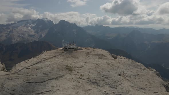 Aerial view: Dolomites in Val Gardena, Italy. Peak of mountain with ski lift and tourists walking, s