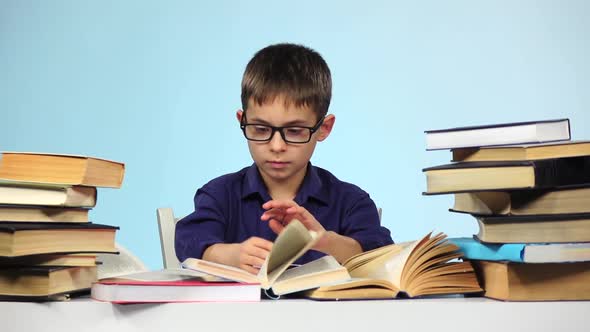 Little Boy Reading a Different Book. Blue Background. Slow Motion