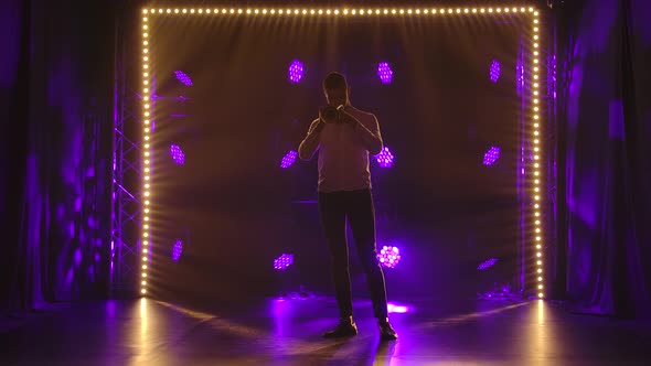 A Jazz Trumpeter Plays of His Trumpet in the Dark Studio with Dynamic Colored Lights. Silhouette