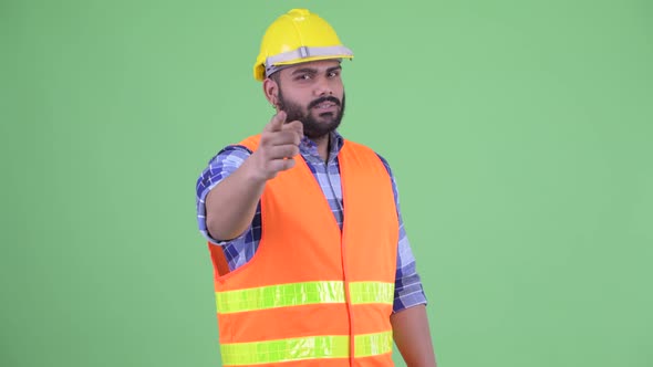 Happy Young Overweight Bearded Indian Man Construction Worker Pointing at Camera