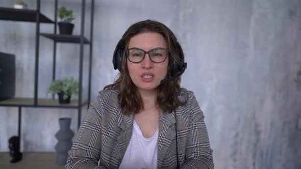 Front View of Business Woman Wearing Headset Working in Office to Support Remote Customer or