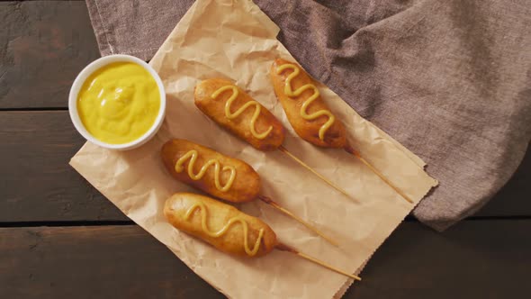 Video of corn dogs with dip on a wooden surface