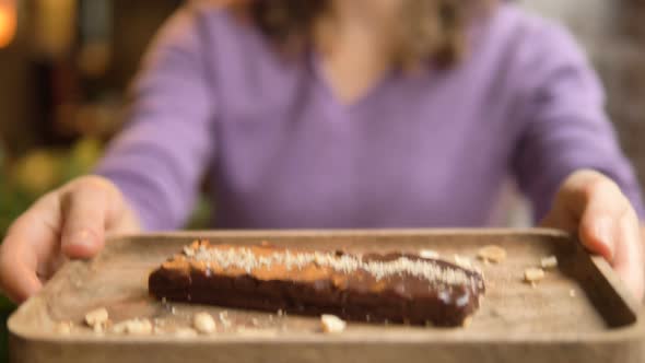 Woman Stretches Hands with Plate and Gluten Free Caramel Bar