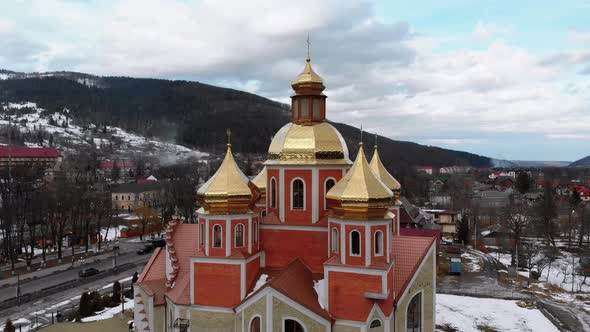 Aerial Drone View of Ukrainian Church with Golden Domes in Carpathian Village in Winter