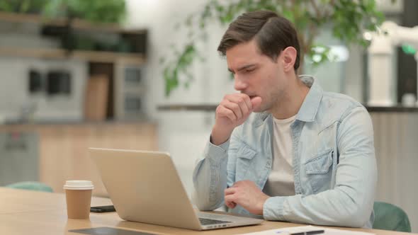 Creative Young Man with Laptop Having Coughing