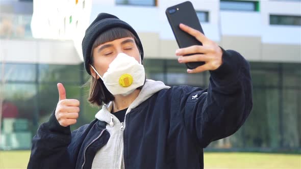 Stylish Hipster Girl Doing Selfies in Respiratory Mask on the Modern Street