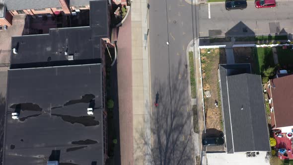 A top down shot taken over a suburban neighborhood on a sunny day. The drone camera looking down dol