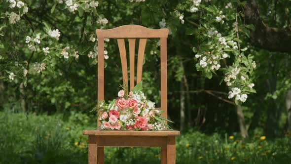 Old Wooden Chair With Flower Bouquet Under The Appletree