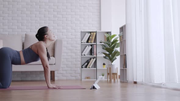 Asian woman practice yoga Cobra pose online course at home