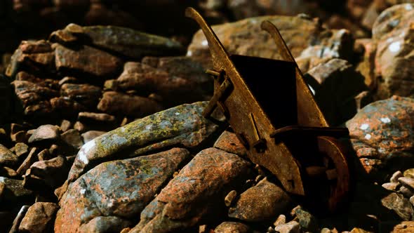 Abandoned Wooden Mine Wheelbarrow on Rocks alt