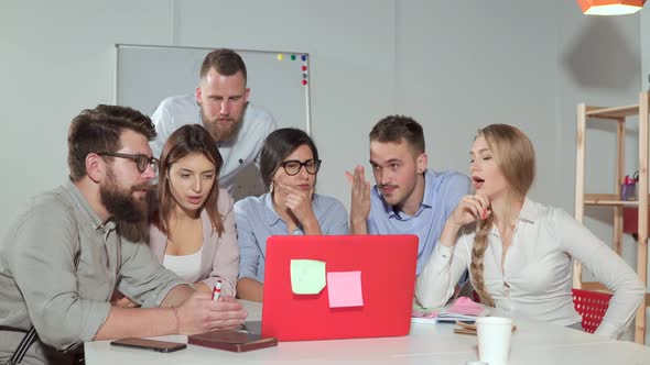 Team Brainstorming in Front of a Laptop