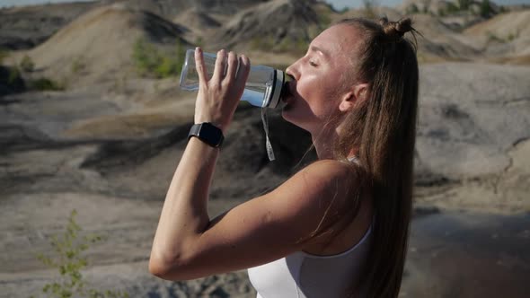 The Girl Is Tired After Training Expires Afterwards and Drinks Water and Bottles