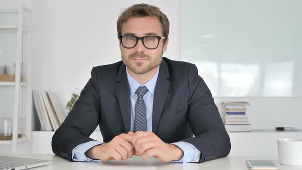 Businessman Looking at Camera in Office